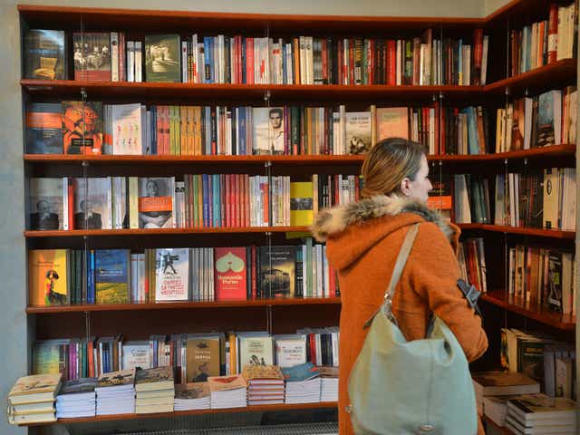 A woman browse a book shop, seeing what cover grabs her fancy
