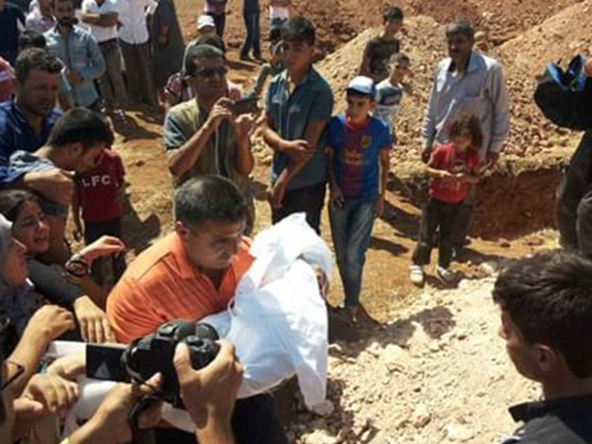 A man carrying one of the deceased children on the way to the burial