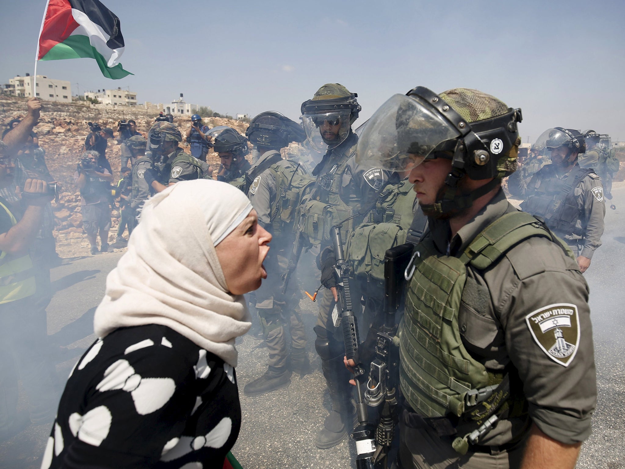 A Palestinian woman argues with an Israeli border policeman during a protest against Jewish settlements in the West Bank village of Nabi Saleh, near Ramallah