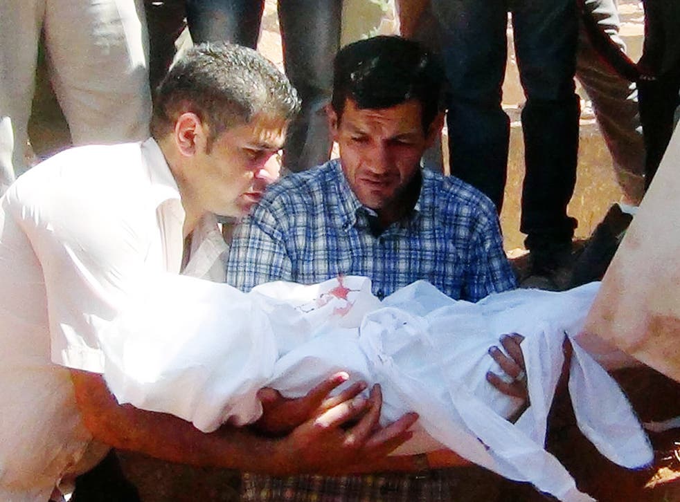 The father of Aylan Kurdi (C) holds the body of his son