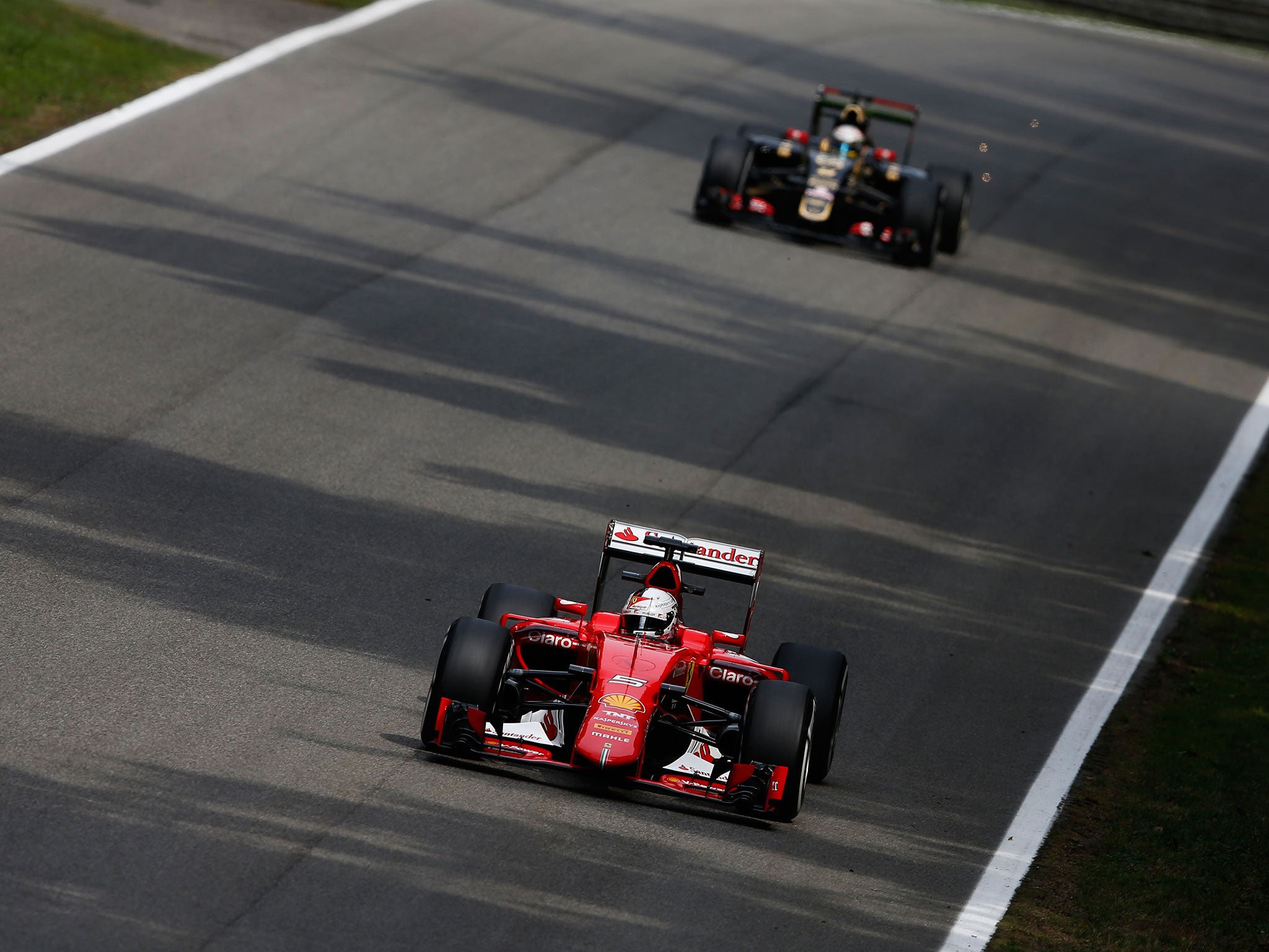 Sebastian Vettel leads Lotus's Romain Grosjean in his Ferrari