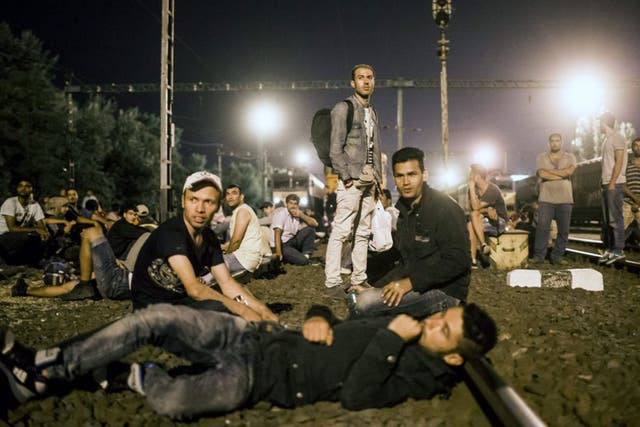 Refugees rest on a track at the Tatabanya Railway Station near Budapest in Hungary on their way to Austria (EPA)