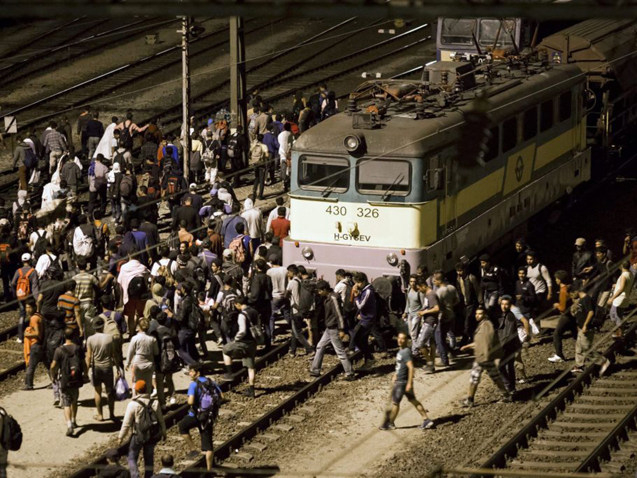 Refugees flood across the tracks at the Tatabanya Railway Station near Budapest in Hungary on their way to Austria 