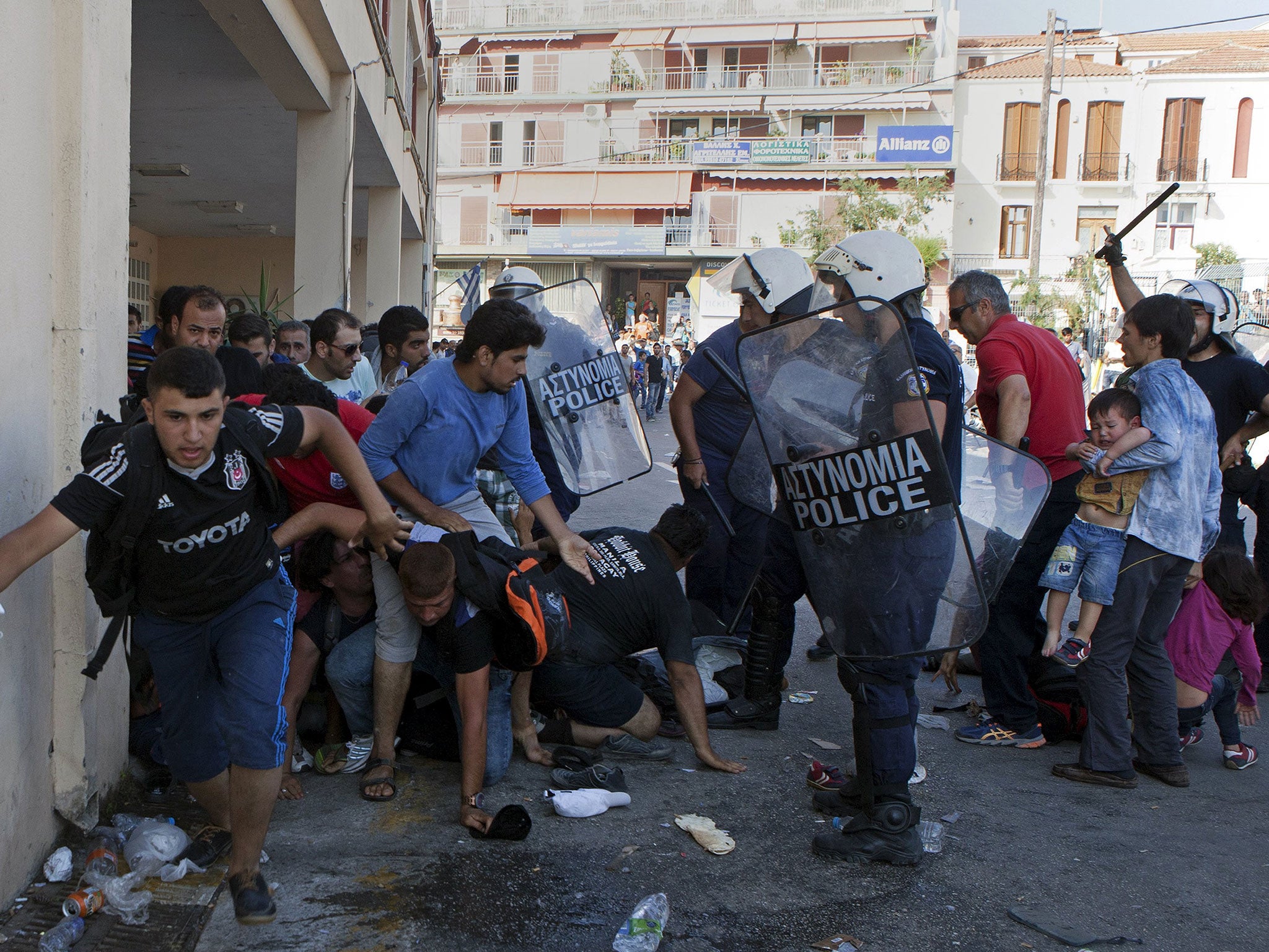 Greek riot police officers disperse Afghan refugees protesting at the port of Mytilene Lesbos on Sunday