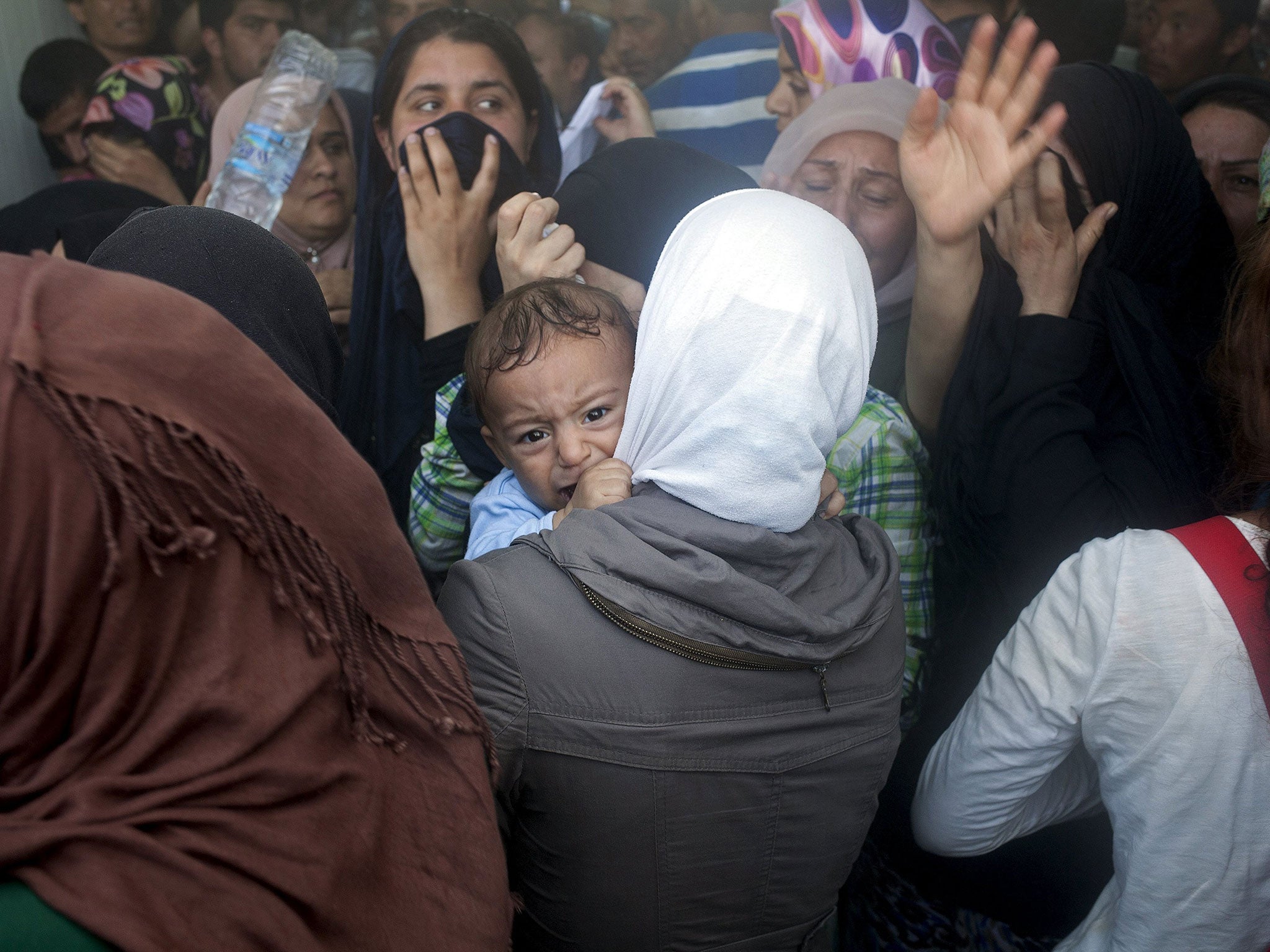 A baby cries during scuffles between refugees and police at the port of Mytilene on the Greek island of Lesbos on 6 September, 2015