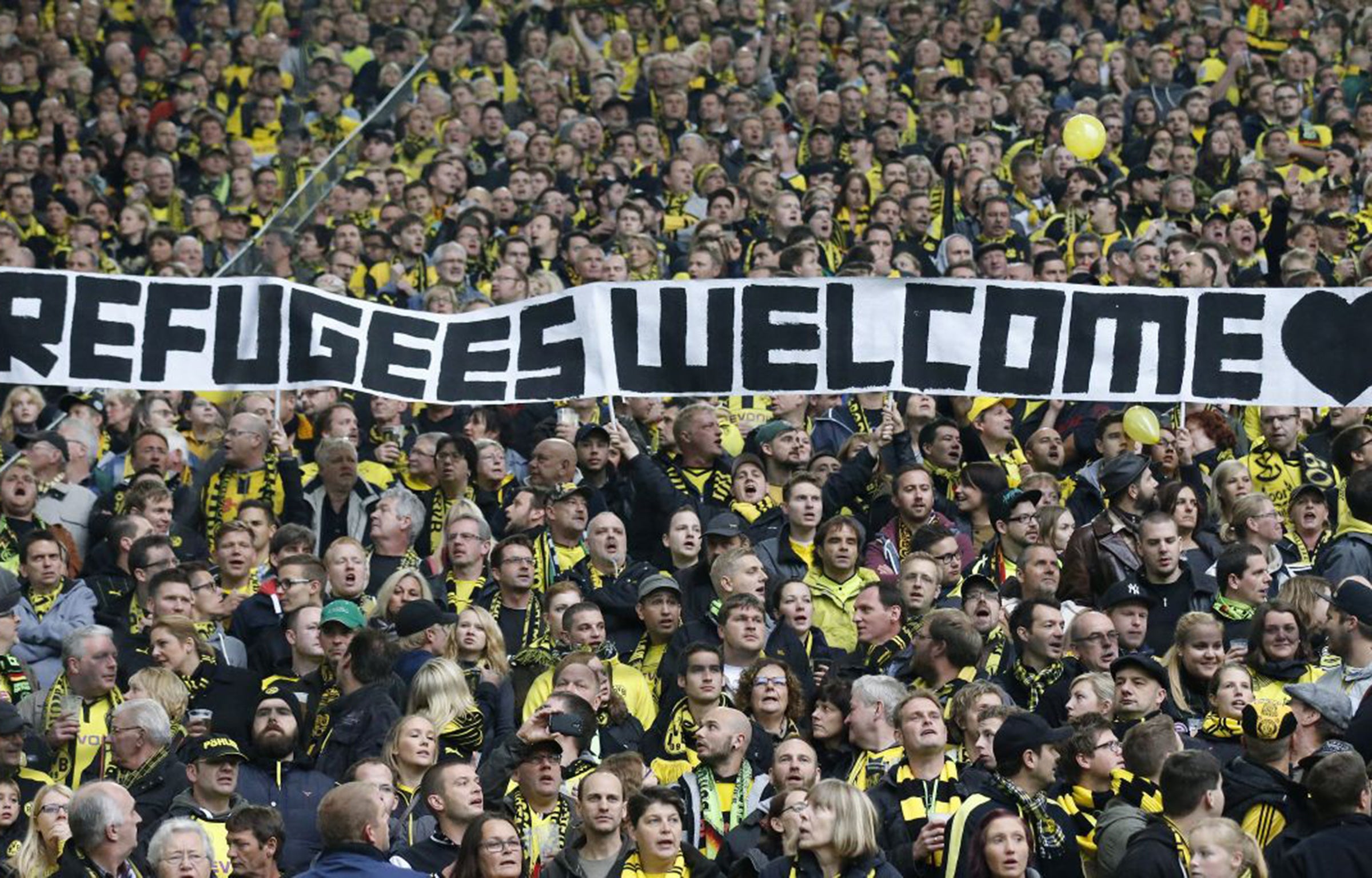 Dortmund supporters hold a banner welcoming refugees to Germany