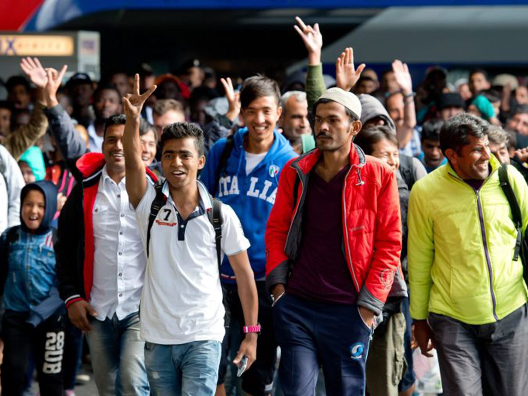 Refugees cheer as they arrive at the main train station in Munich, Germany, 06 September 2015