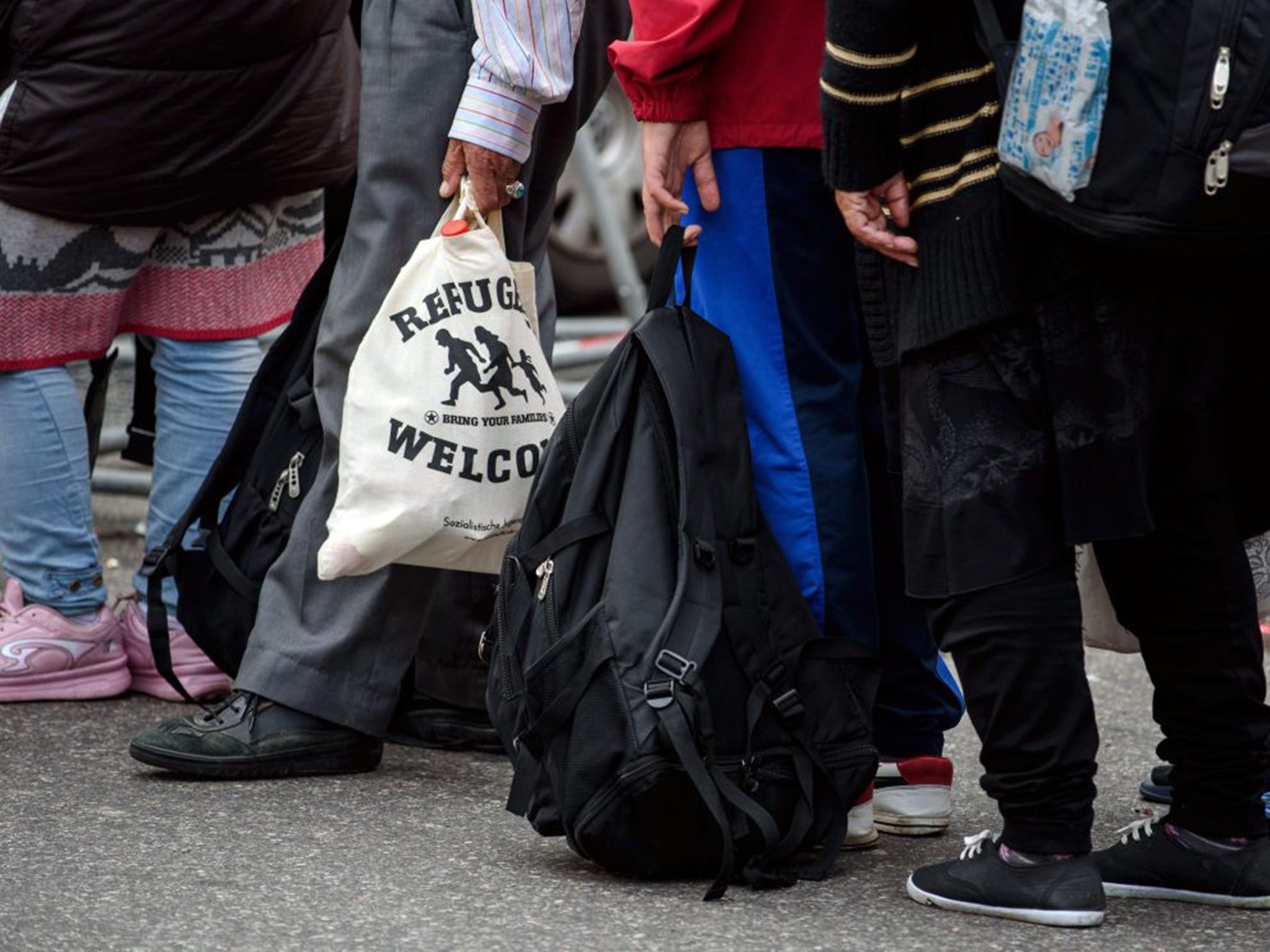 A refugee carries a bag which reads 'Refugees Welcome' upon his arrival at the main train station in Munich (EPA)