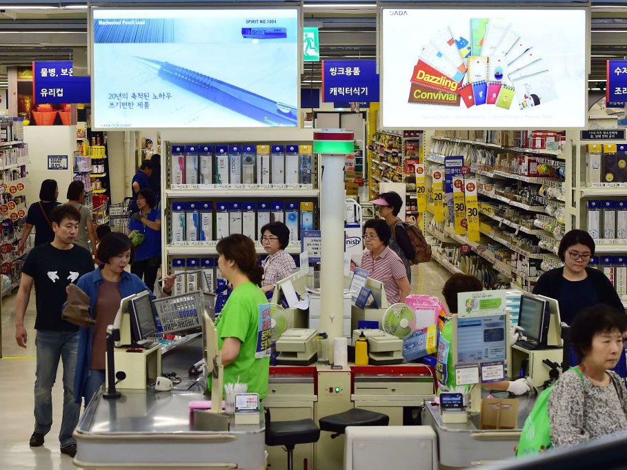 Customers buy goods at the Homeplus retail store, South Korea's number two supermarket chain, in Seoul on September 7, 2015.