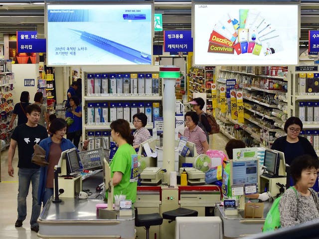 Customers buy goods at the Homeplus retail store, South Korea's number two supermarket chain, in Seoul on September 7, 2015. 