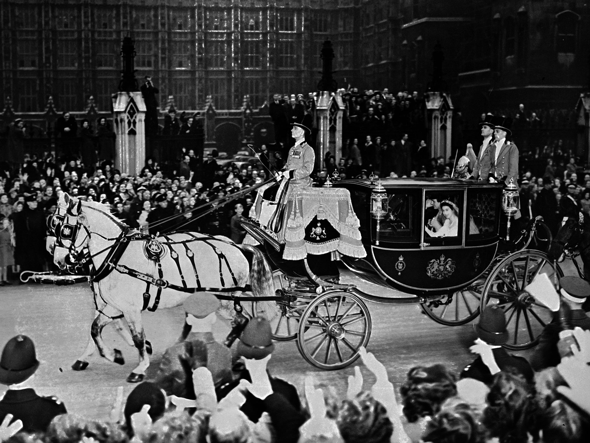 Elizabeth and her husband Prince Philip are cheered by the crowd after their wedding ceremony, on 20 November 1947, on their road to Buckingham Palace, London
