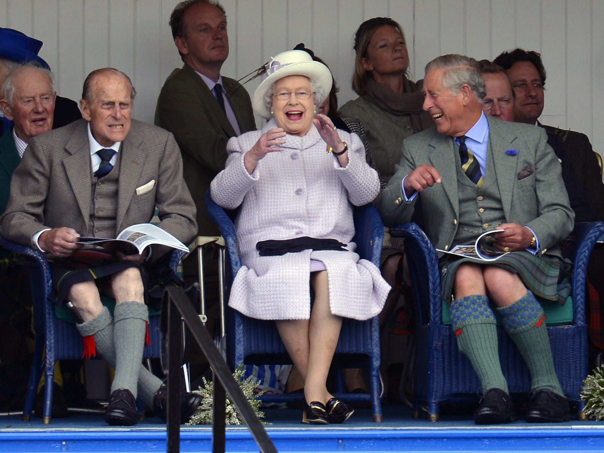 Members of Britain's royal family (front L to R) Prince Philip, Queen Elizabeth and Prince Charles cheer as competitors participate in a sack race at the Braemar Gathering in Braemar, Scotland, 2012