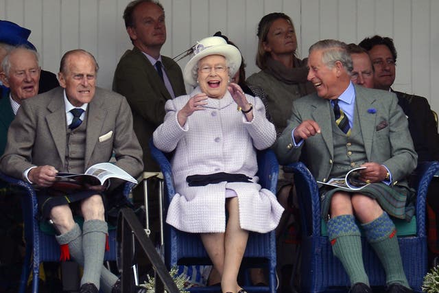 Members of Britain's royal family (front L to R) Prince Philip, Queen Elizabeth and Prince Charles cheer as competitors participate in a sack race at the Braemar Gathering in Braemar, Scotland, 2012 