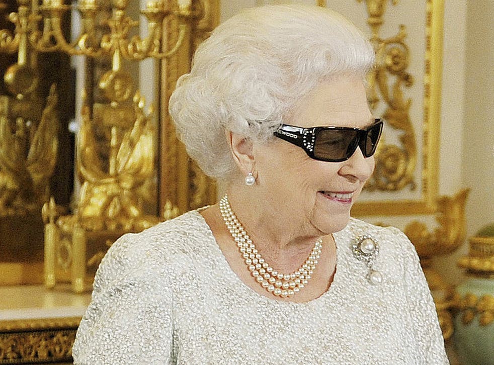Queen Elizabeth watches a preview of her Christmas message wearing a pair of 3D glasses, studded with Swarovski crystals in the form of a "Q", at Buckingham Palace in central London, 2012
