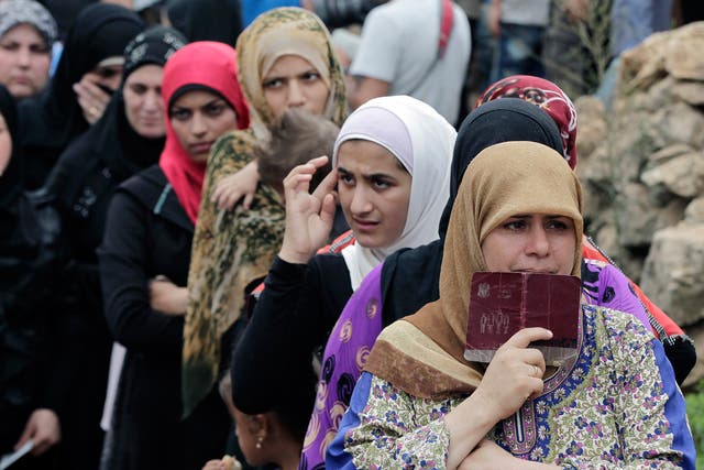 Syrian women wait in line to receive aid from an Islamic relief agency at a refugee camp in the town of Ketermaya. There are some 1.2 million registered Syrian refugees in Lebanon