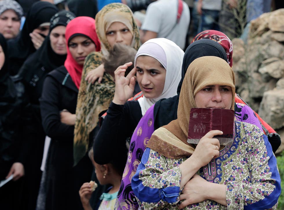Syrian women wait in line to receive aid from an Islamic relief agency at a refugee camp in the town of Ketermaya. There are some 1.2 million registered Syrian refugees in Lebanon