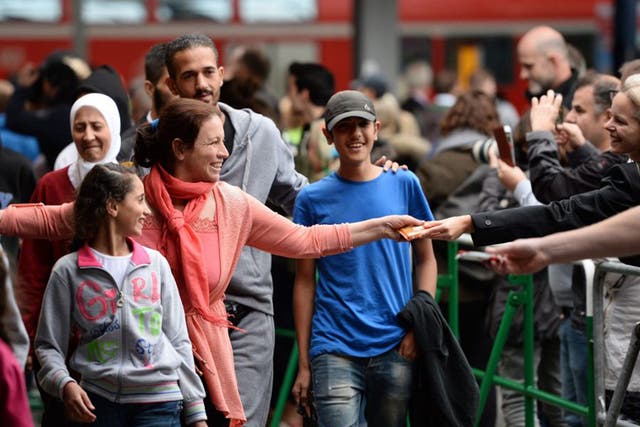 Refugees arrive at the central railway station in Munich, welcomed with open arms