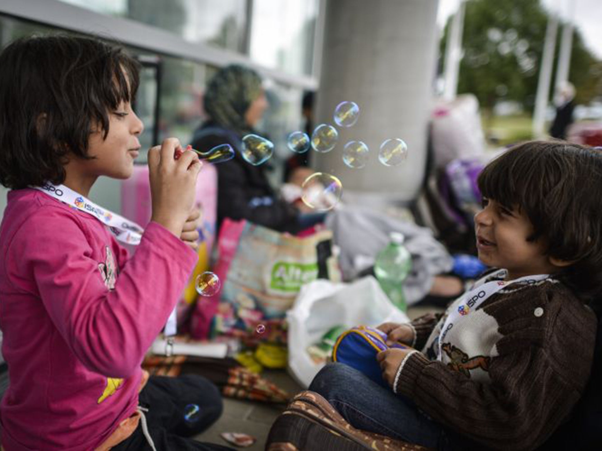 Rinad, left, and Tolen, from Syria, play at a refugee accommodation facility in an exhibition hall in Munich