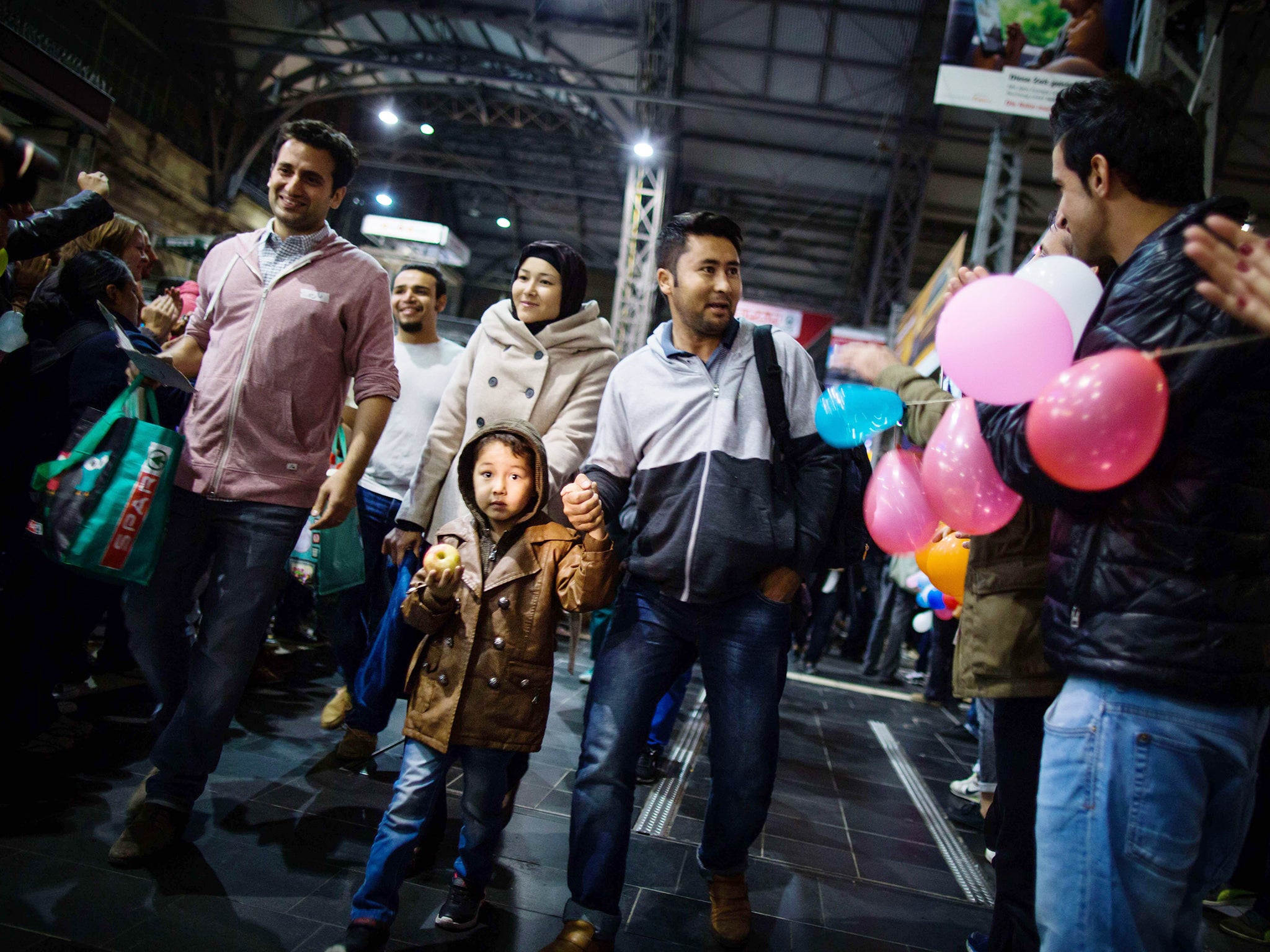 Migrants are welcomed by locals after their arrival at the main railway station in Frankfurt, Germany. Over 1,000 more migrants arrived in Germany to cheers and "welcome" signs, but calls grew for a European solution to its worst refugee crisis since Worl