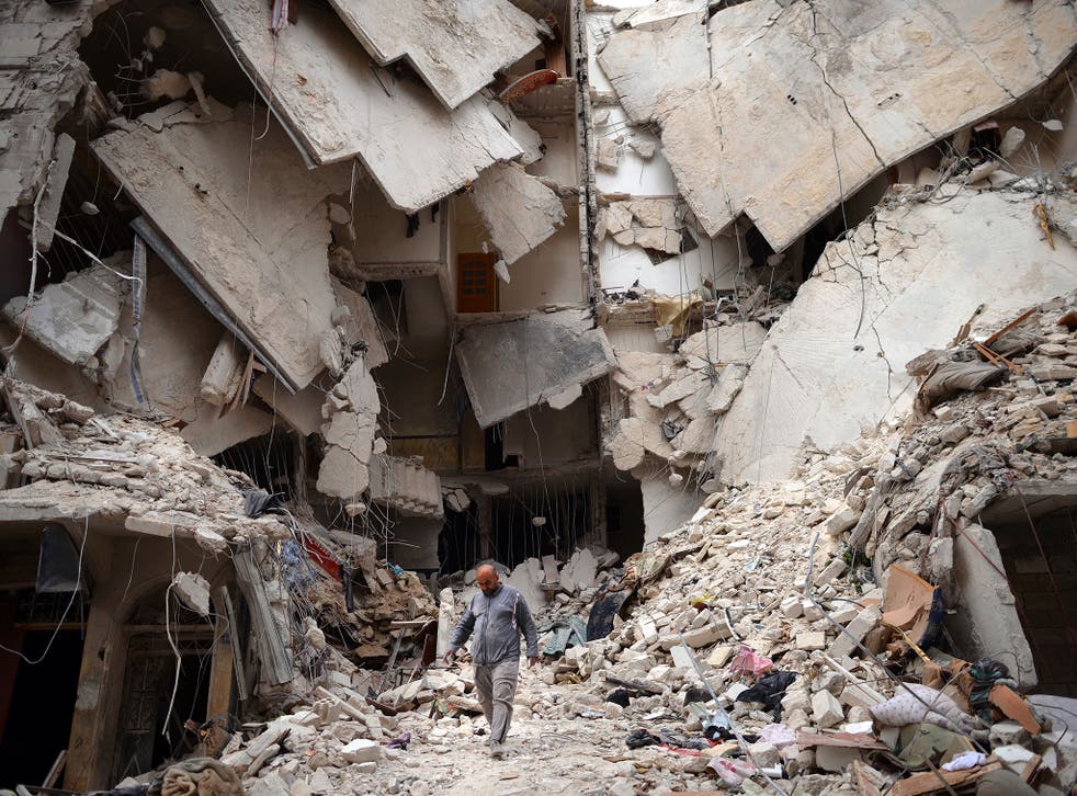 A Syrian man walks amid destruction in the northern Syrian city of Aleppo