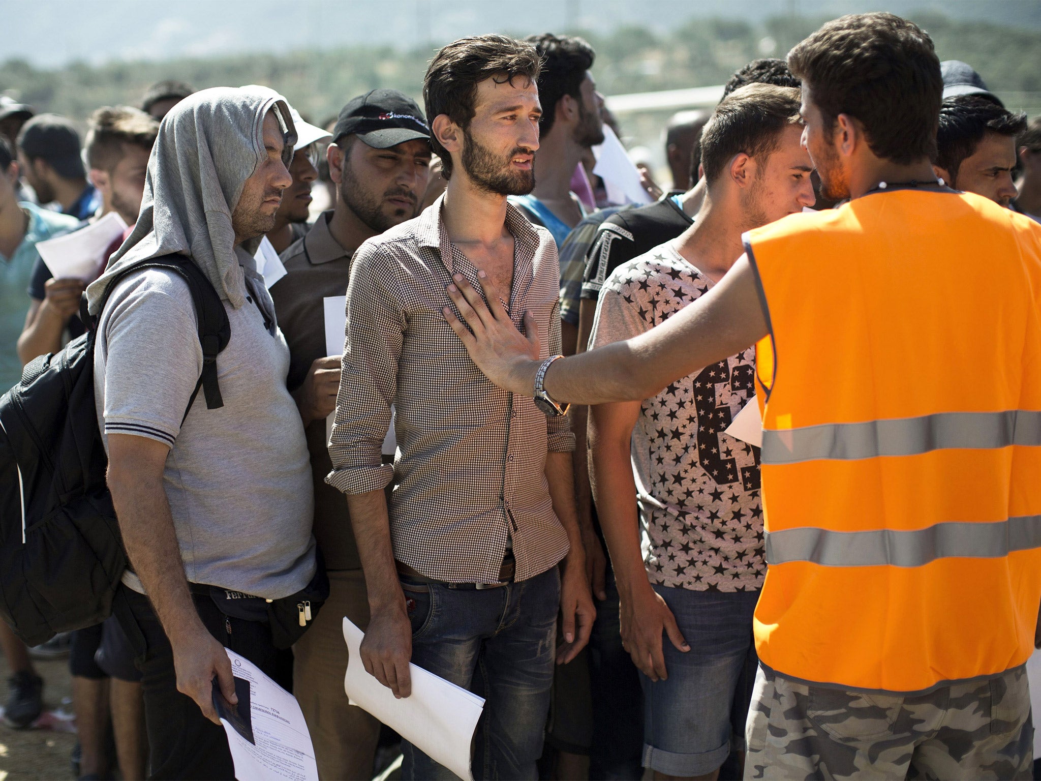 Refugees, mainly from Syria, wait at a registration center held at a stadium on the Greek island of Lesbos