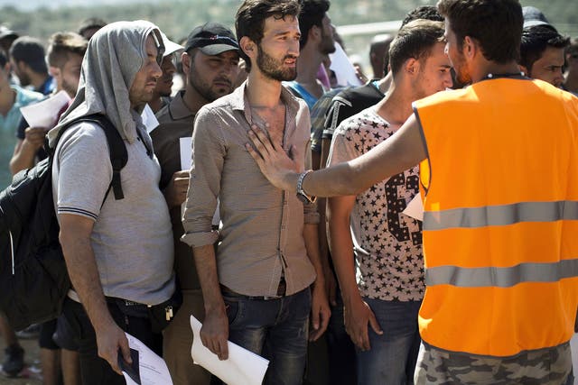 Refugees, mainly from Syria, wait at a registration center held at a stadium on the Greek island of Lesbos
