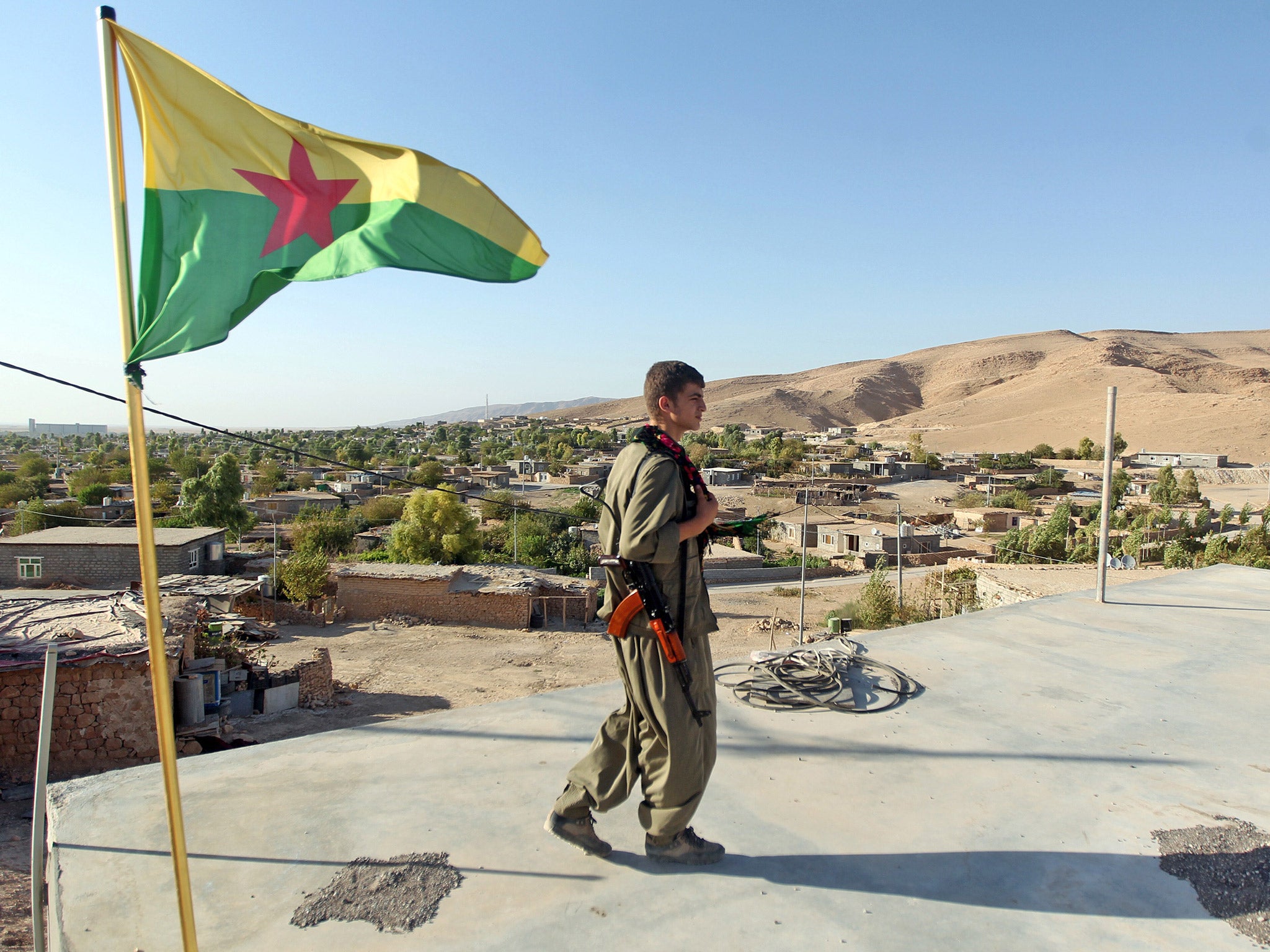 A Kurdistan Workers Party (PKK) fighter guards a post flying the group's flag in the town of Makhmur, northern Iraq, last year