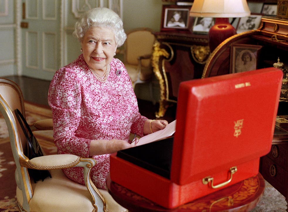 Britain's Queen Elizabeth sits in her private audience room in Buckingham Palace next to one of her official red boxes in which she receives documents and papers from government officials in the United Kingdom and the Commonwealth as Britain marks the mom