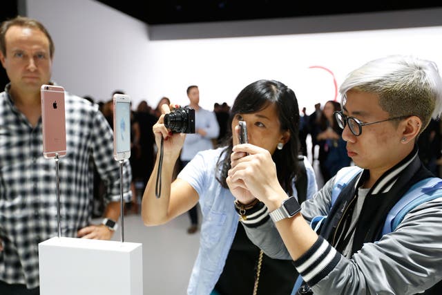 Members of the media photograph the new apple iPhone 6s in rose gold after an Apple special event at Bill Graham Civic Auditorium September 9, 2015 in San Francisco, California