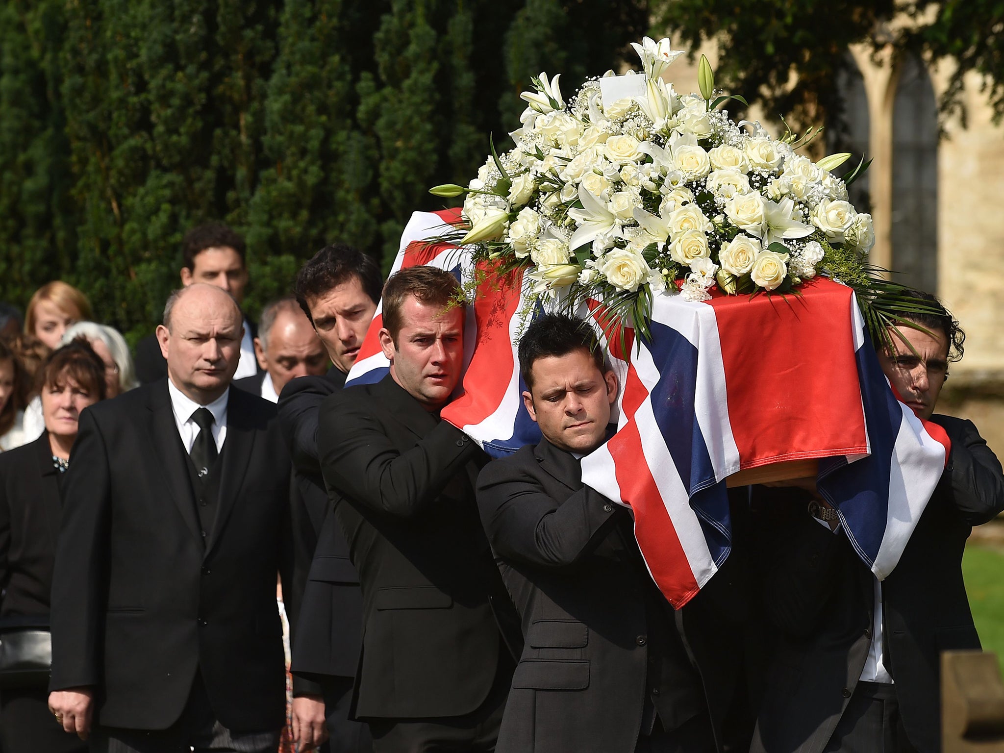 The coffin of Justin Wilson is carried Mark Webber (back left) and Dario Franchitti (right) after his funeral at St James the Great Church in Paulerspury