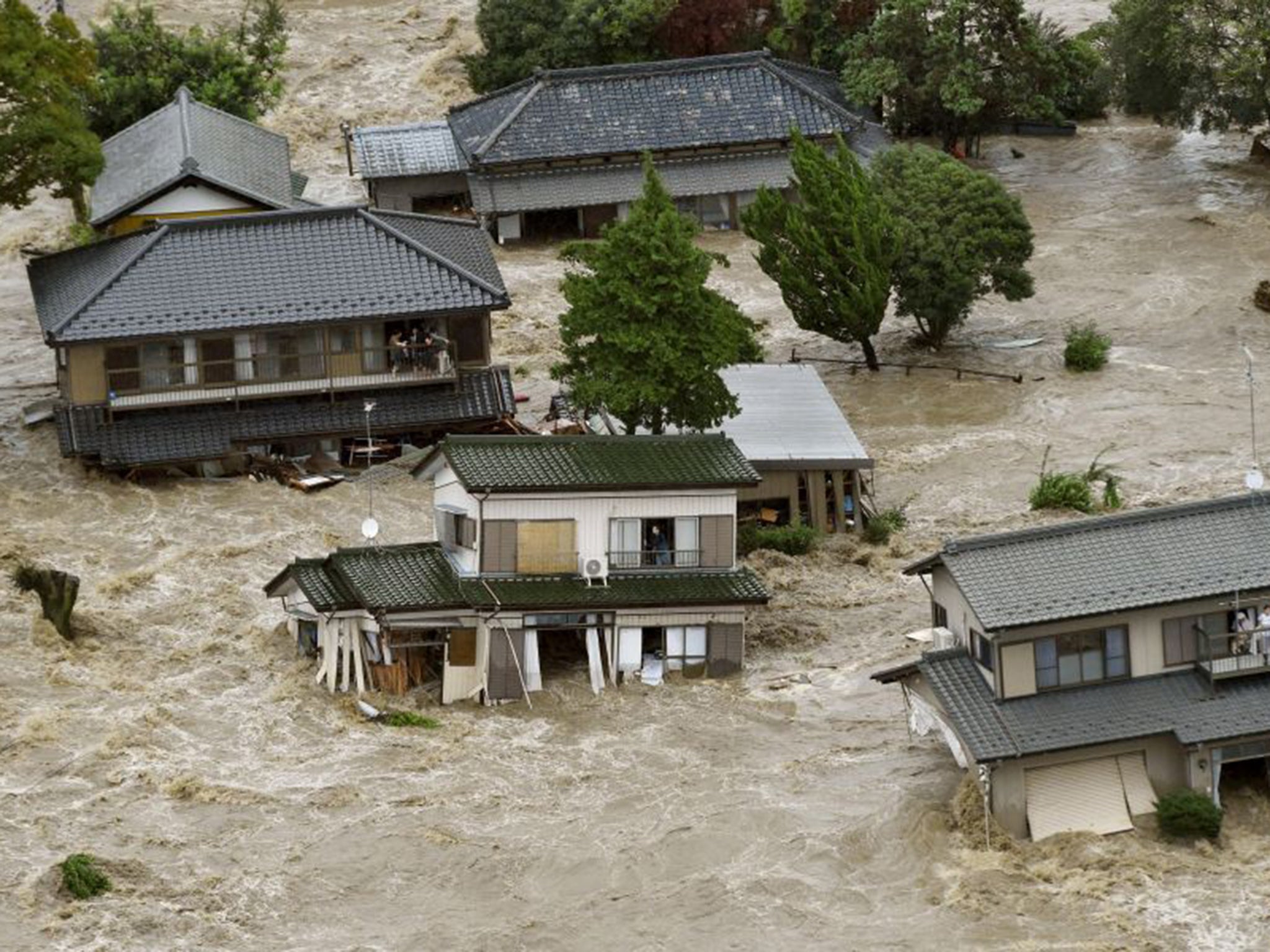 Terrified residents wait for evacuation by helicopter as the overflowing Kinugawa River rages through Joso, Ibaraki prefecture; 90,000 people were forced to flee their homes