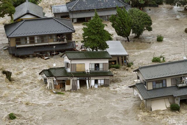 Terrified residents wait for evacuation by helicopter as the overflowing Kinugawa River rages through Joso, Ibaraki prefecture; 90,000 people were forced to flee their homes 