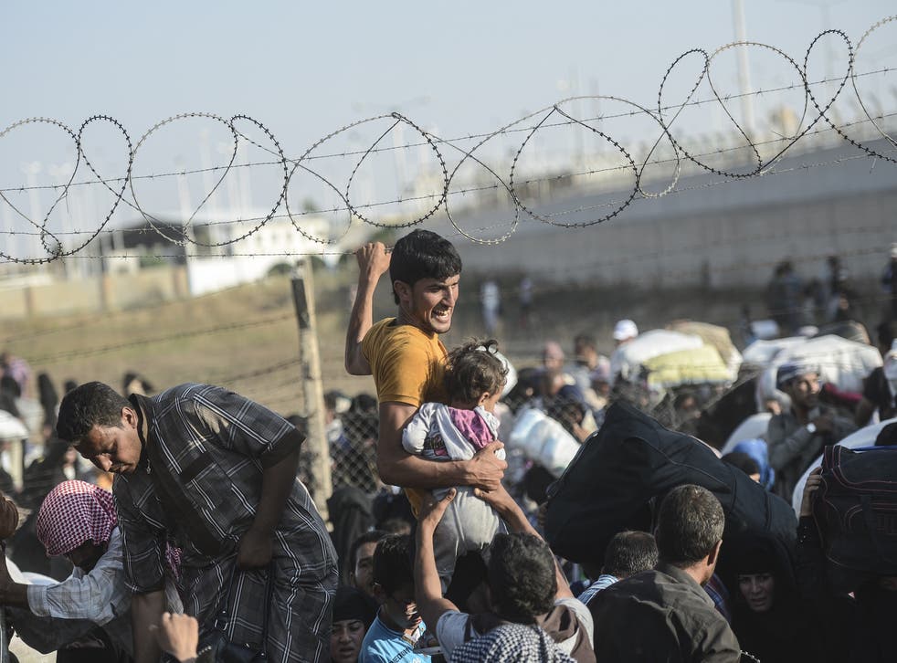Syrians pass through border fences into Turkish territory.