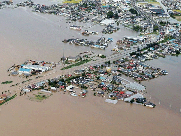 An aerial view shows houses and rice fields flooded by the Shibui river in Osaki, Miyagi