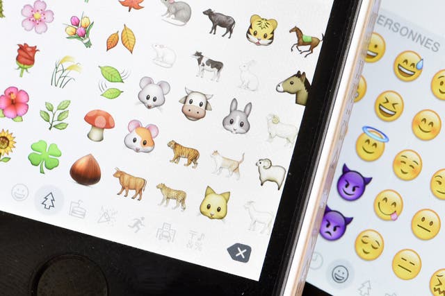 A picture shows emoji characters also known as emoticons on the screens of two mobile phones in Paris on August 6, 2015