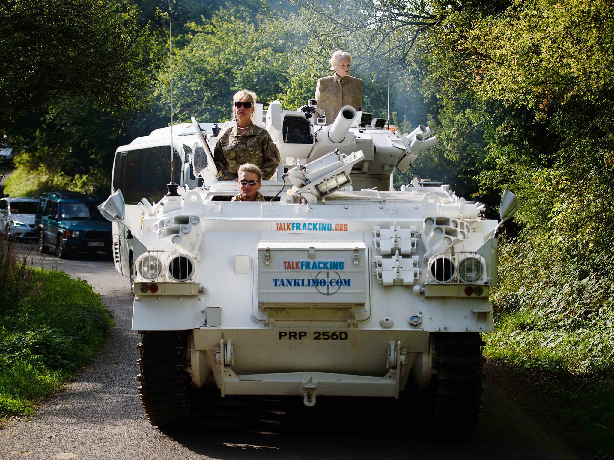 Fashion designer and environmental campaigner Vivienne Westwood (R) rides on top of an armored personnel carrier (APC) towards the home of British Prime Minister David Cameron's home in Chadlington, Oxfordshire, to highlight the Government's plan to use h