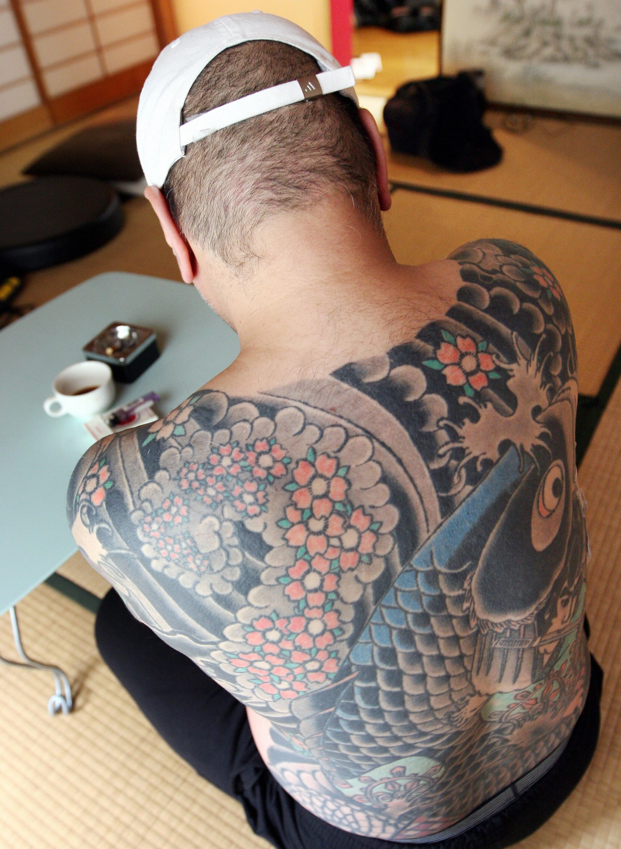 A retired Yakuza boss shows a traditional set of the mob's full body 'irezumi' tattoos