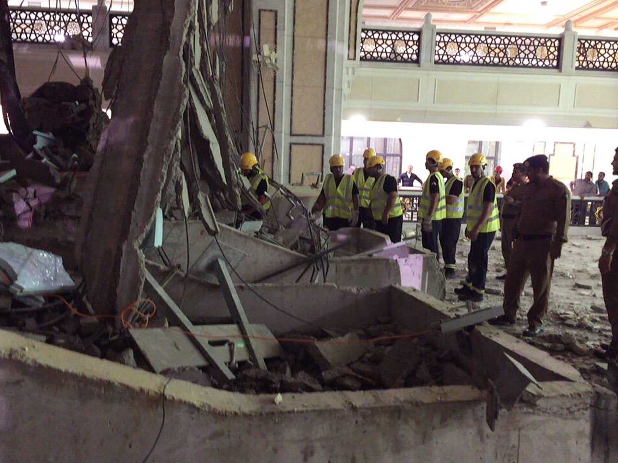 Civil Defense personnel inspect the damage at the Grand Mosque in Mecca after a crane collapsed killing dozens, Friday, Sept. 11, 2015