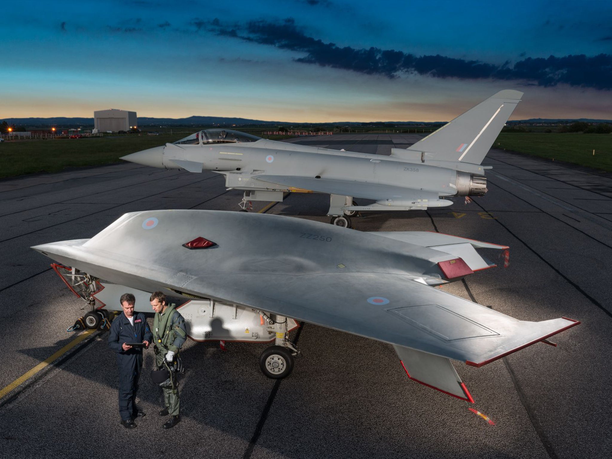 A new Taranis drone in front of a piloted Typhoon jet fighter