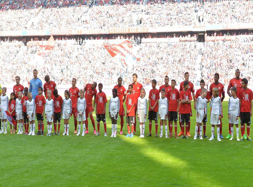 Bayern players each held hands with a German child on one side and a migrant child on the other