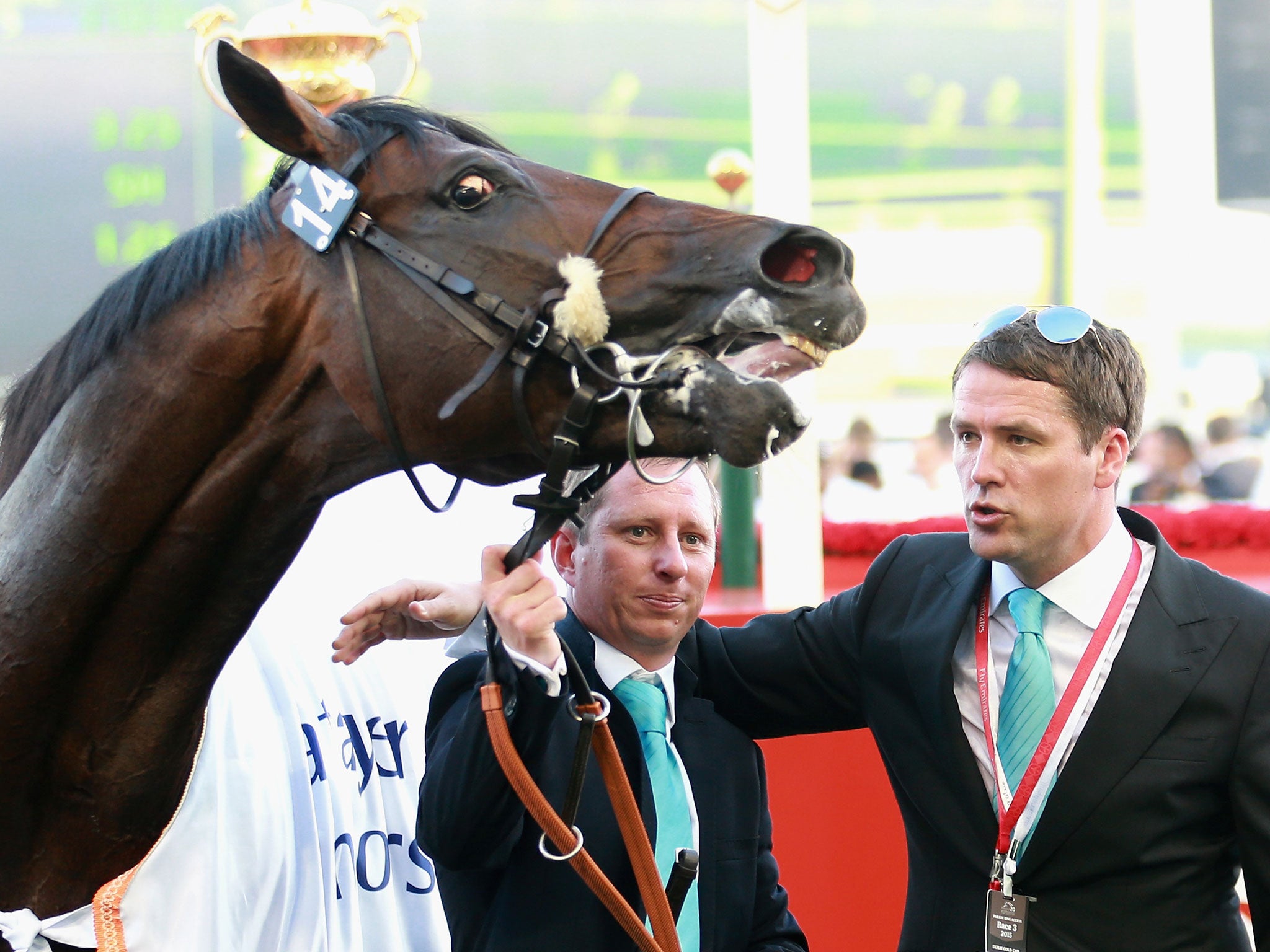 Former England international footballer Michael Owen and trainer Tom Dascombe pose with Brown Pather after winning Dubai Gold Cup during the Dubai World Cup earlier this year