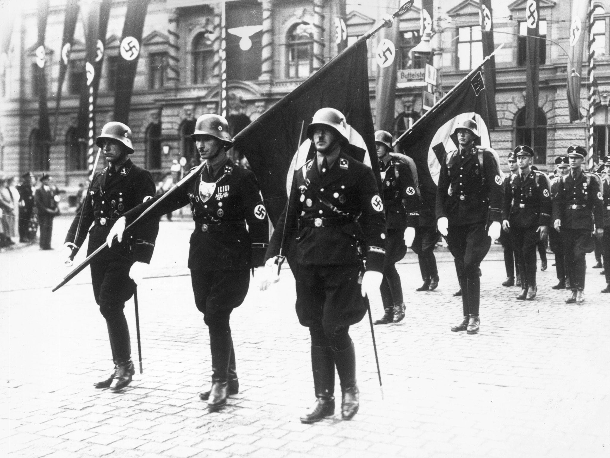 Nazi stormtroopers in Weimar, carrying swastika flags in ceremonial dress