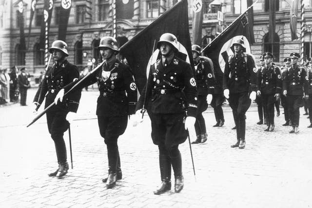 Nazi stormtroopers in Weimar, carrying swastika flags in ceremonial dress
