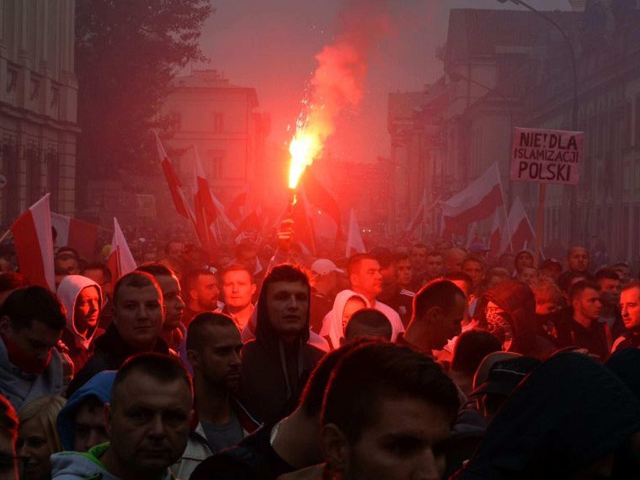 Right-wing demonstrators light fireworks during a protest against refugees in Warsaw