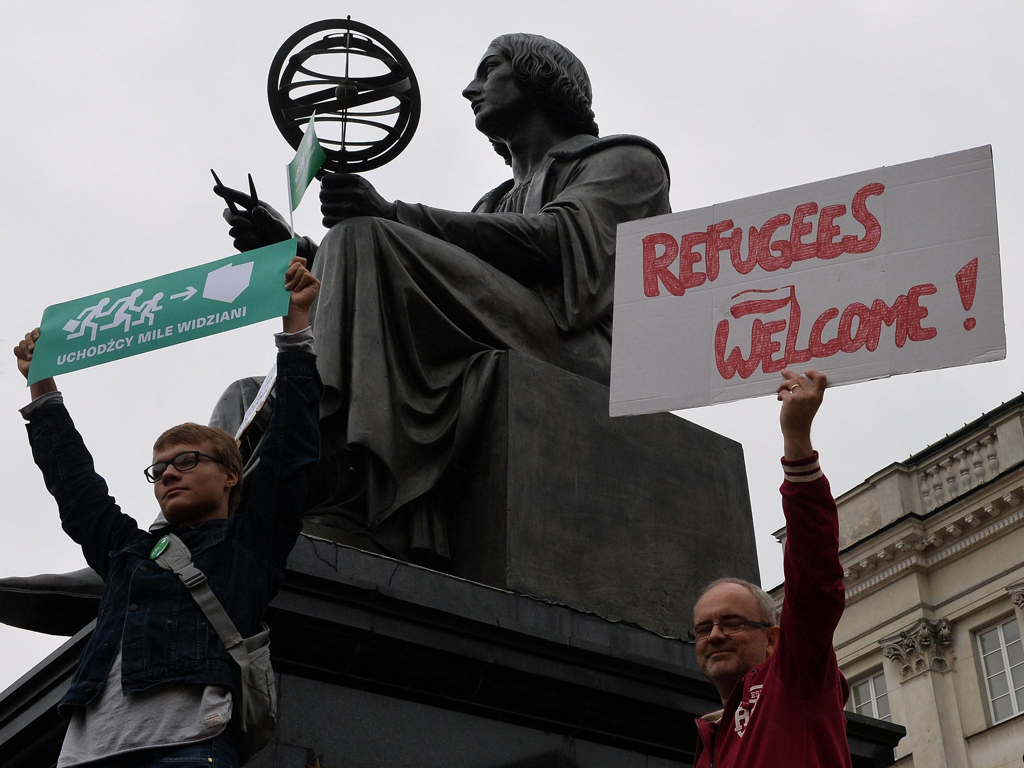 A protester holds a placard reading 'Refugees welcome' in Warsaw (Image: AFP)