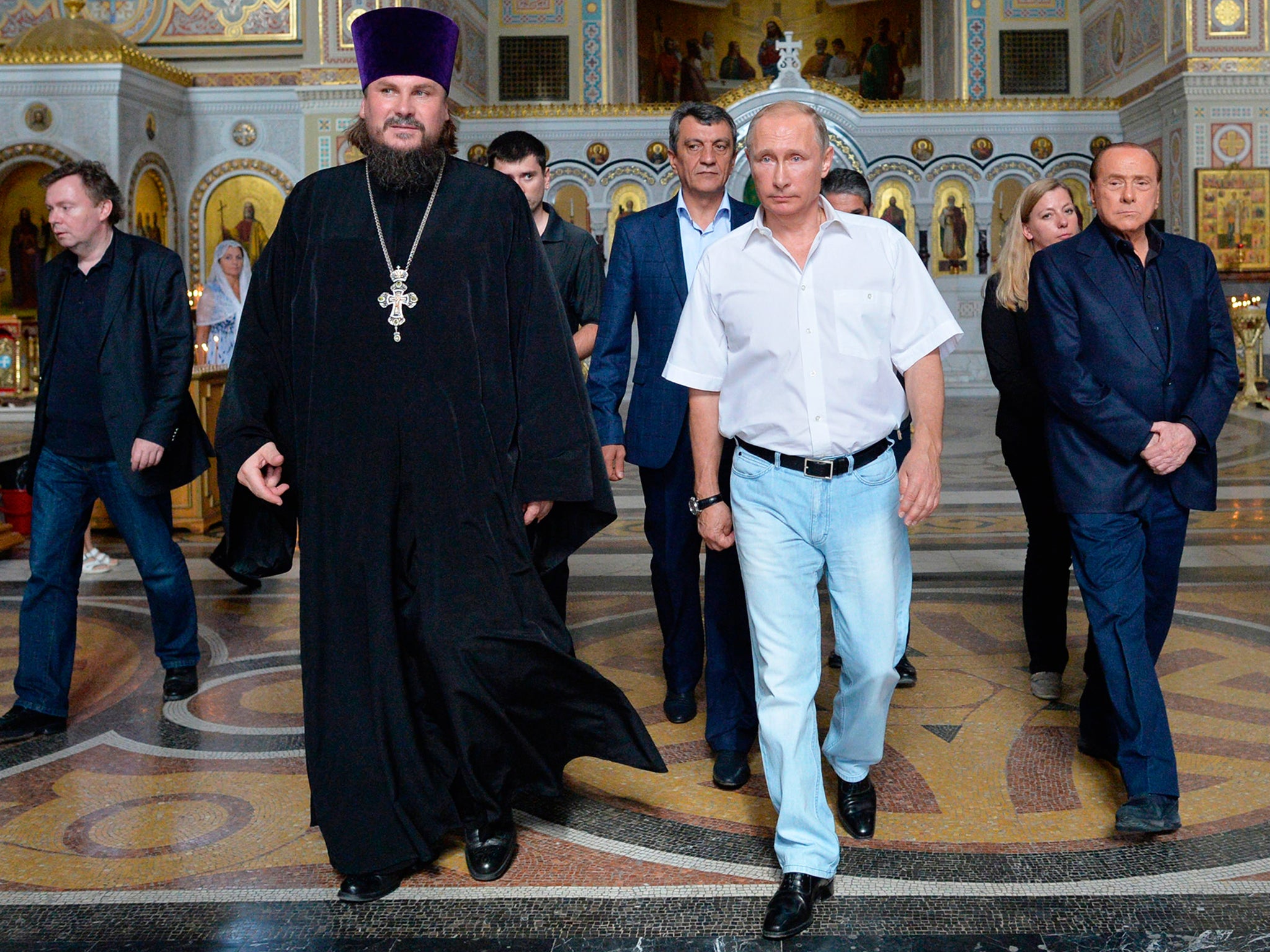 Russian President Vladimir Putin, second right, and former Italian Prime Minister Silvio Berlusconi, right, walk in St. Vladimir's Cathedral as they visit the ancient Greek colony of Chersonesus, major archaeological site in Crimea, outside Sevastopol, Crimea