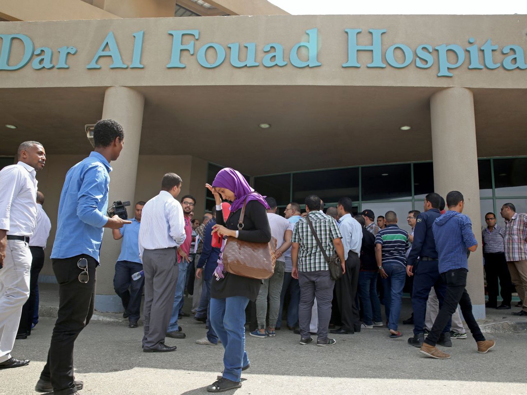 Egyptian journalists wait for information outside the Dar Al Fouad Hospital in Cairo. At least 12 tourists were killed and 10 injured on a desert safari trip