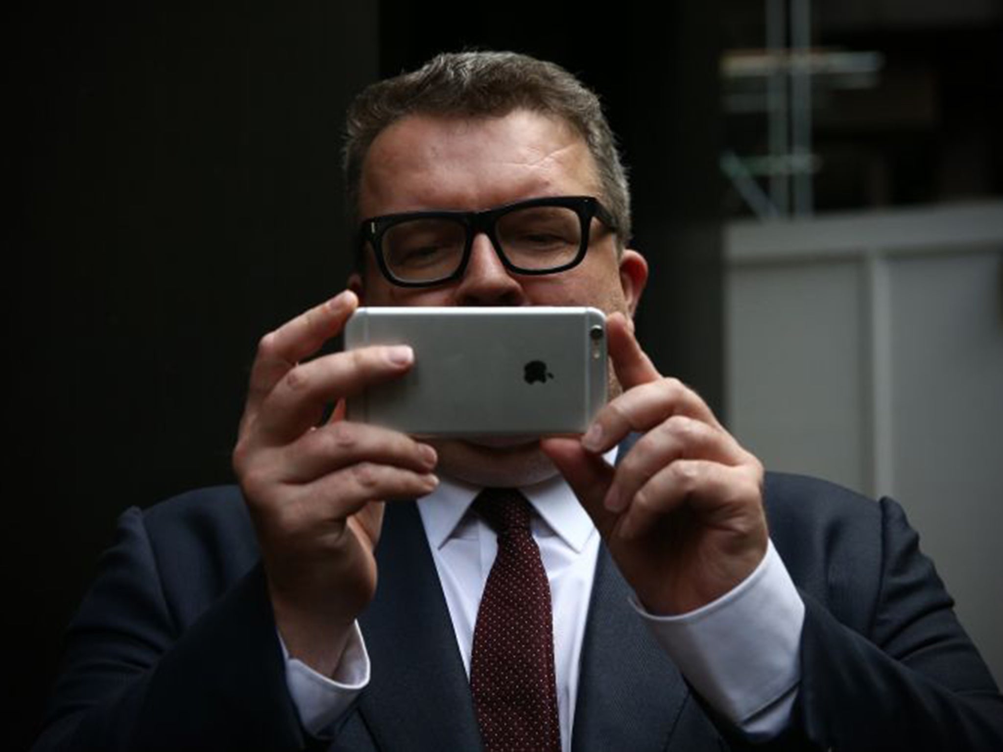 Labour’s new deputy leader Tom Watson takes a photograph of the media as he leaves party HQ