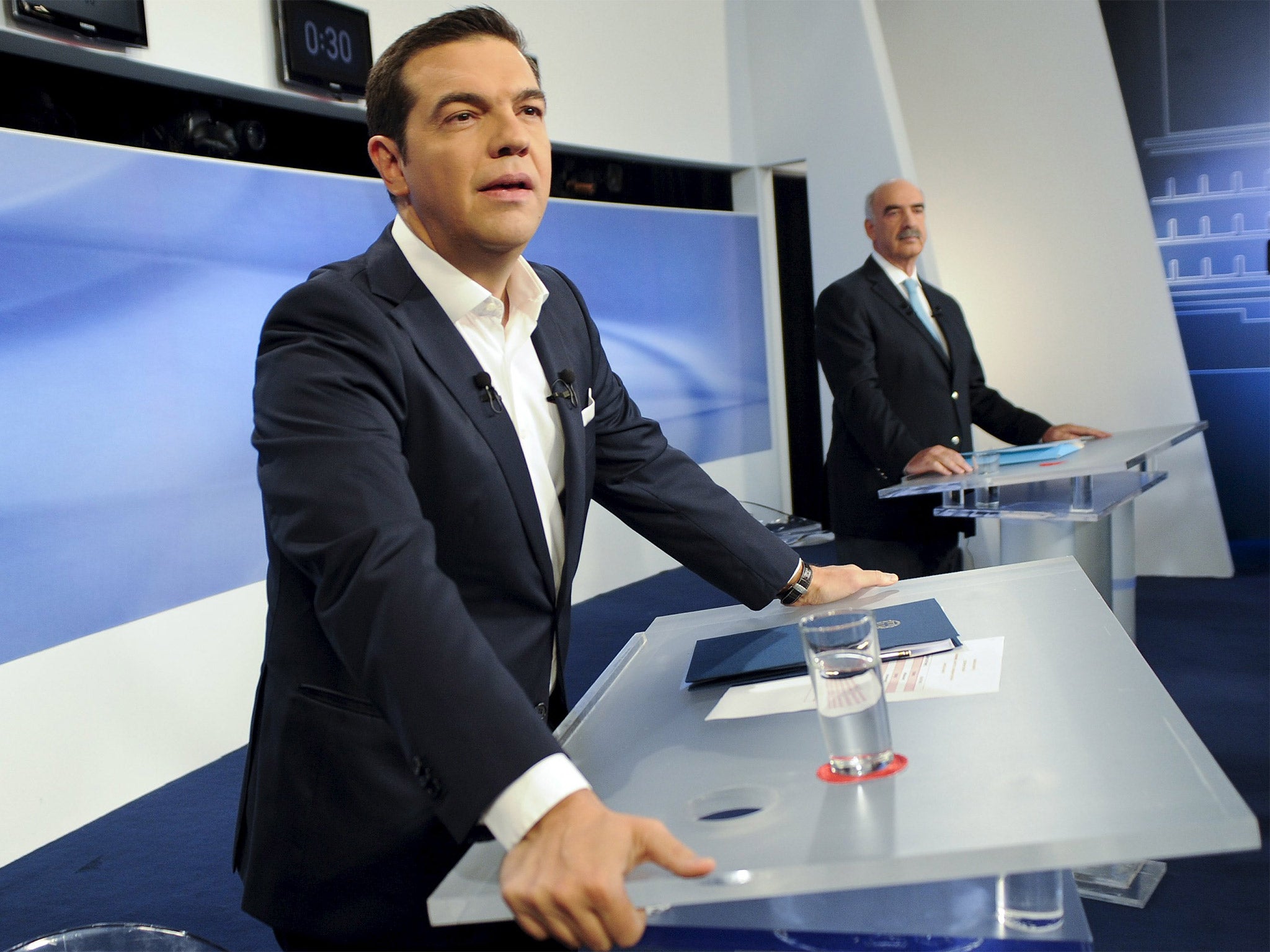 Syriza party leader Alexis Tsipras and New Democracy party leader Vangelis Meimarakis stand at their podiums during the televised debate in Athens