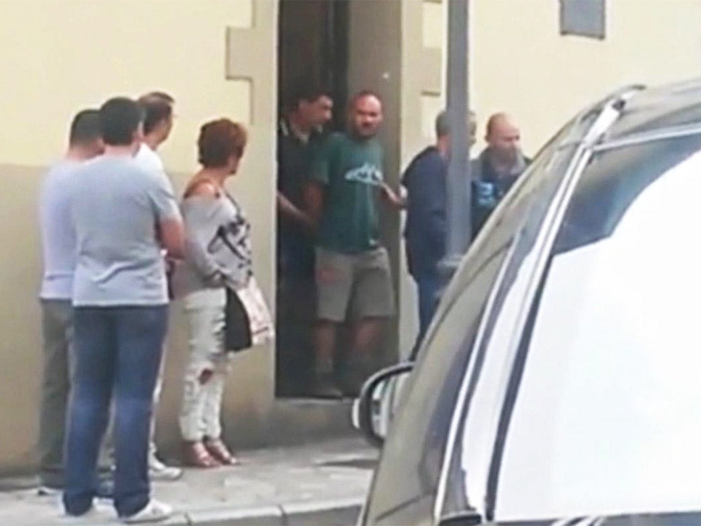 Authorities lead suspect Miguel Angel Munoz out of a building in Grandas de Salime, northwest Spain (AP)